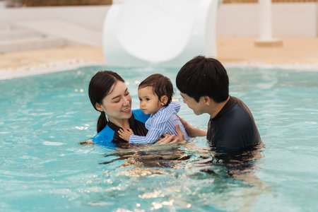happy family. father and mother with small daughter playing in swimming pool.の写真素材