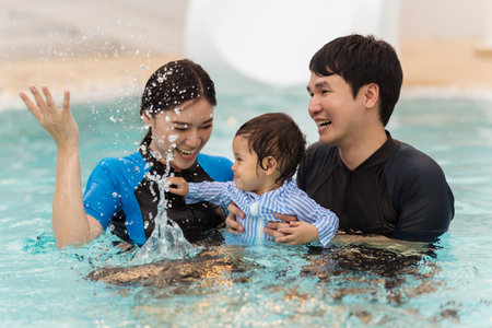 happy family. father and mother with small daughter playing in swimming pool.の写真素材