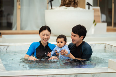 happy family. father and mother with small daughter playing in swimming pool.の写真素材