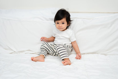 toddler baby on a bedの写真素材