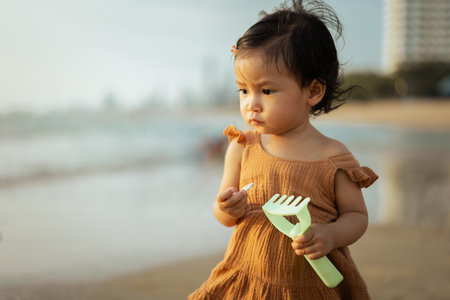 toddler baby girl standing on the sea beachの写真素材