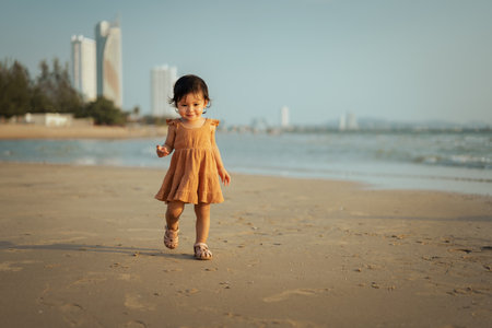 happy toddler baby girl walking on the sea beachの写真素材