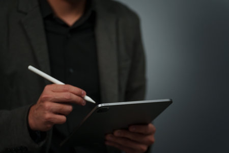businessman hand using stylus pen touching on digital tablet with blank empty visual screenの写真素材