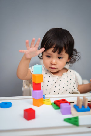 toddler baby playing block toy to stacks building cubes on the tableの写真素材