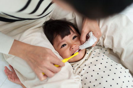 mother brushing her little daughters teeth. happy baby with tooth brushの写真素材
