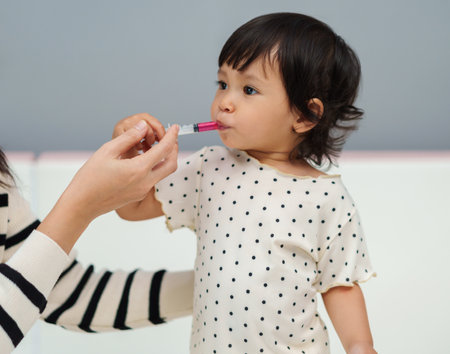 mother feeding a liquid medicine to baby girl by syringe. sick toddlerの写真素材