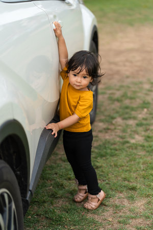 toddler baby girl opening door of the carの写真素材