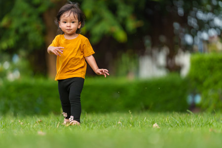 happy toddle baby girl walking in the parkの写真素材