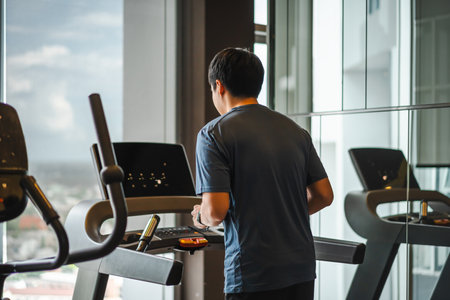 young man running on treadmill at fitness gym exercise