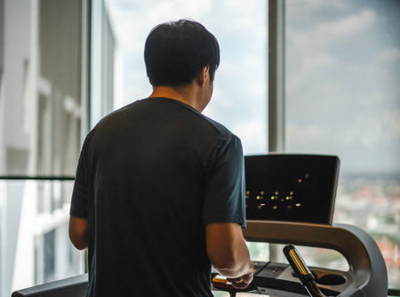 young man running on treadmill at fitness gym exercise