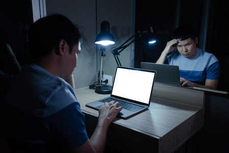 stressed man headache while working with laptop at a night (with clipping path)の写真素材