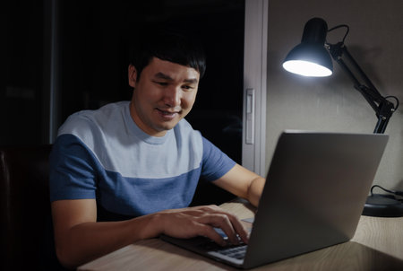 happy man working with laptop at a nightの写真素材