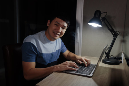 happy man working with laptop at a nightの写真素材