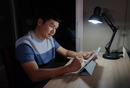 man working with digital tablet at a nightの写真素材