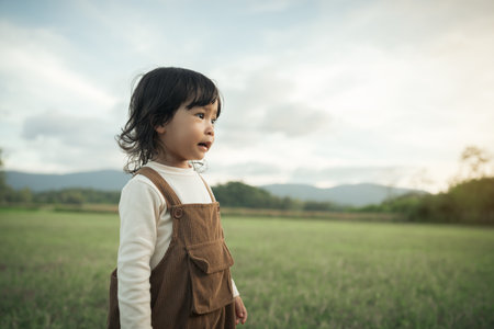 happy toddle baby girl on a grass fieldの写真素材