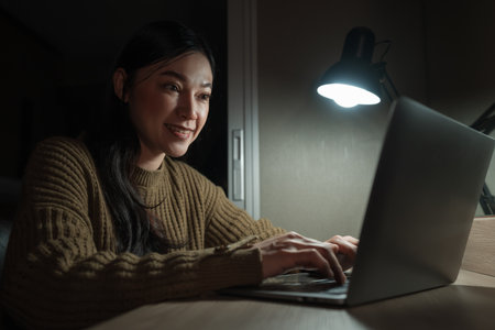 happy woman working with laptop at a nightの写真素材