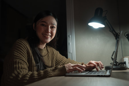 happy woman working with laptop at a nightの写真素材