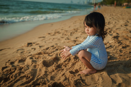 toddler baby girl sitting on the sea beach in Pattaya, Thailandの写真素材