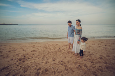 toddler baby girl with her father and mother. happy family on the sea beach  in Pattaya, Thailandの写真素材
