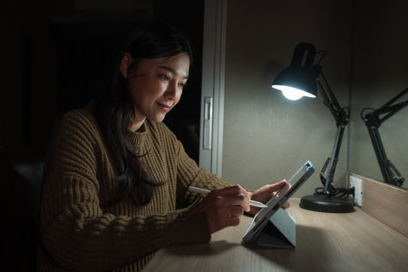 woman working with digital tablet at a nightの写真素材