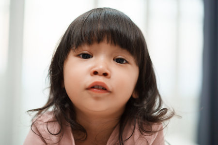 close up of happy toddler girl in bedroom