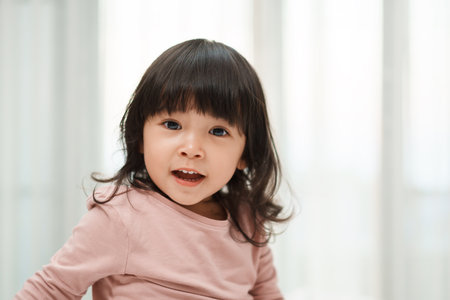 close up of happy toddler girl in bedroomの写真素材