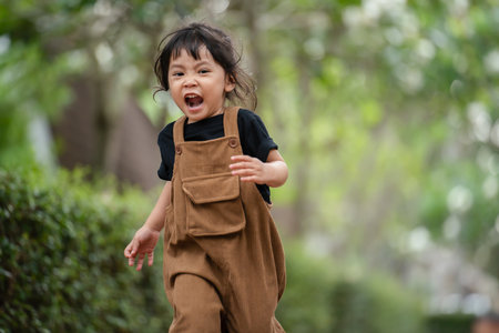 happy toddler girl running on in the gardenの写真素材