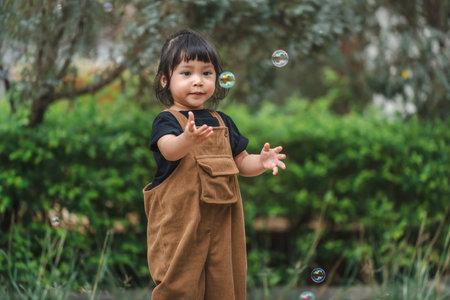 toddler girl playing soap bubble in the parkの写真素材