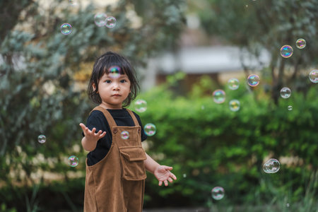 toddler girl playing soap bubble in the parkの写真素材