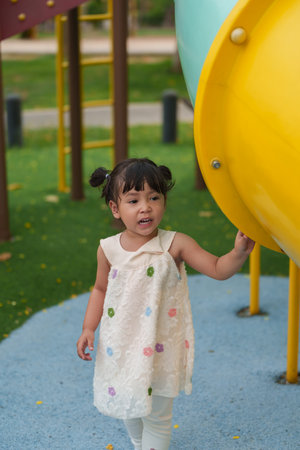 happy toddler girl playing at a outdoor playground in the parkの写真素材