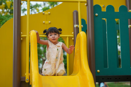 happy toddler baby girl playing at outdoor playground in the parkの写真素材
