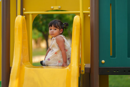 happy toddler baby girl playing at outdoor playground in the parkの写真素材