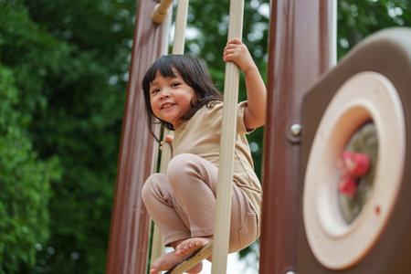 happy toddler girl playing at a outdoor playground in the parkの写真素材