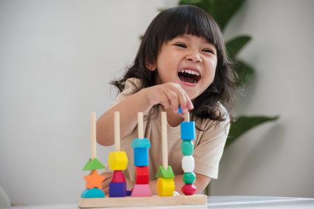 toddler girl playing educational wooden toy at homeの写真素材