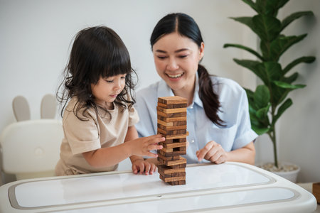 toddler girl with her mother playing wooden block toy togetherの写真素材