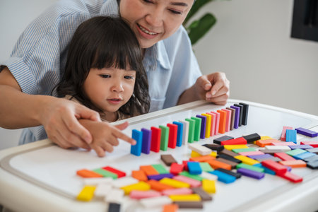 toddler girl and her mother playing colorful wooden block toy or domino game togetherの写真素材