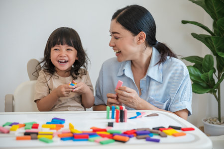 toddler girl and her mother playing colorful wooden block toy or domino game togetherの写真素材