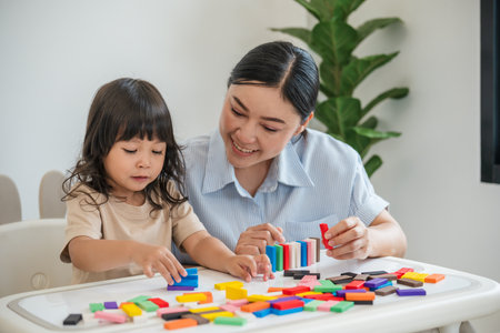 toddler girl and her mother playing colorful wooden block toy or domino game togetherの写真素材