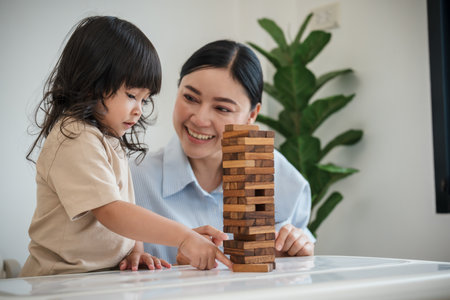 toddler girl with her mother playing wooden block toy togetherの写真素材