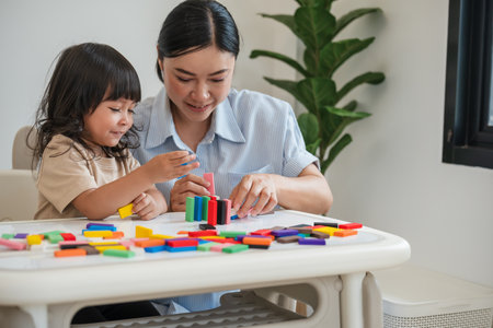 toddler girl and her mother playing colorful wooden block toy or domino game togetherの写真素材