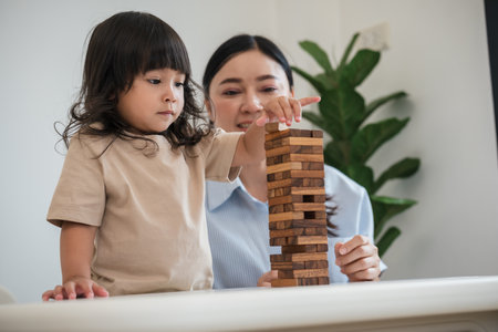 toddler girl with her mother playing wooden block toy togetherの写真素材