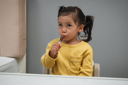 toddler girl takes syrup medicine with syringe by herself. sick childの写真素材