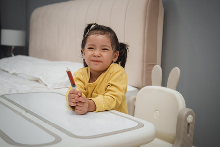 happy toddler girl holding syrup medicine with syringeの写真素材