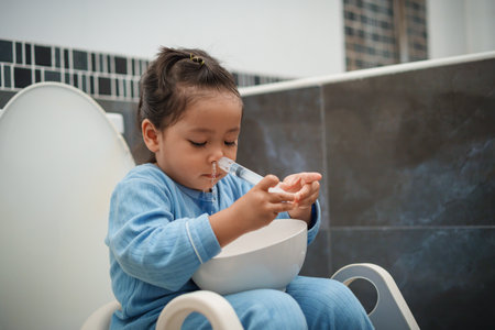 toddler girl washing nasal with syringe and saline by herself. cleaning baby noseの写真素材