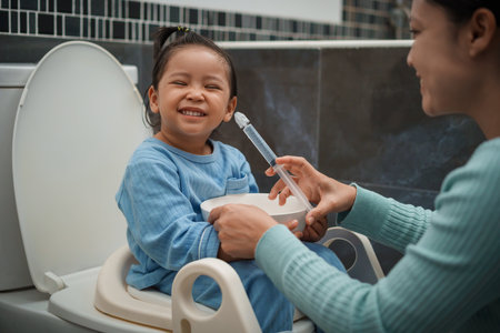 mother making nasal wash for happy toddler girl with syringe and saline. cleaning baby noseの写真素材
