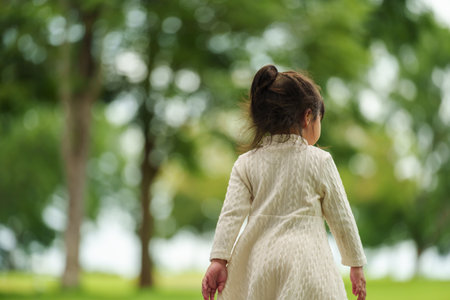 toddler girl walk along a pathway in the parkの写真素材