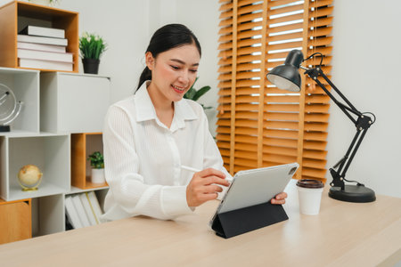 happy woman working with a digital tablet at home officeの写真素材
