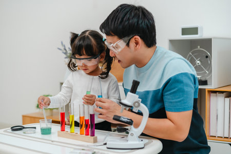 toddler girl scientist study using pipette dropping liquid with test tube and beaker. learning...