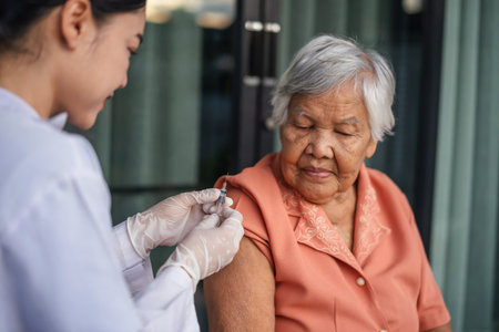 doctor holding syringe and making injection a vaccine to senior woman