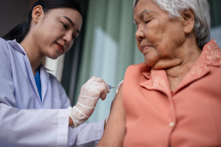 doctor holding syringe and making injection a vaccine to senior womanの写真素材